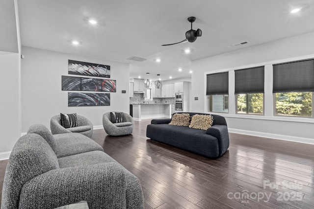 living room featuring ceiling fan and dark hardwood / wood-style flooring