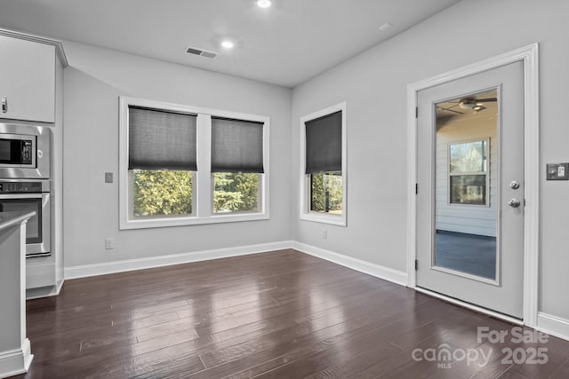 unfurnished dining area with dark wood-type flooring