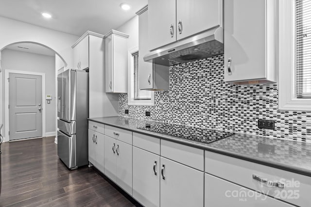 kitchen featuring white cabinets, black electric stovetop, stainless steel fridge, and backsplash