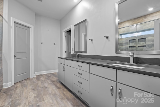 bathroom with vanity, a shower with shower door, and wood-type flooring