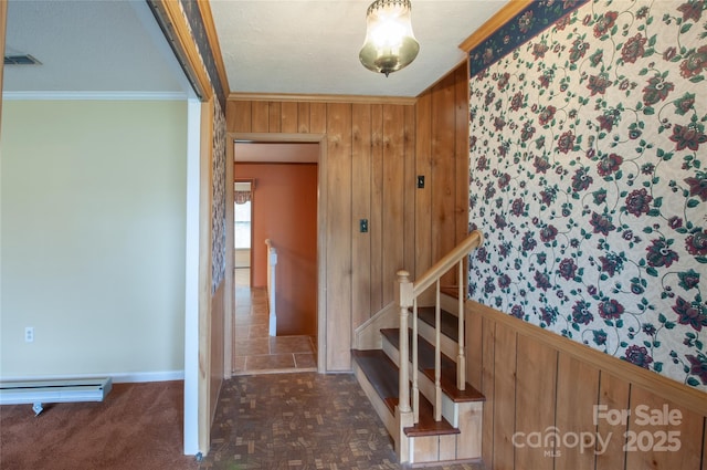 staircase featuring crown molding, a baseboard radiator, parquet flooring, and wood walls