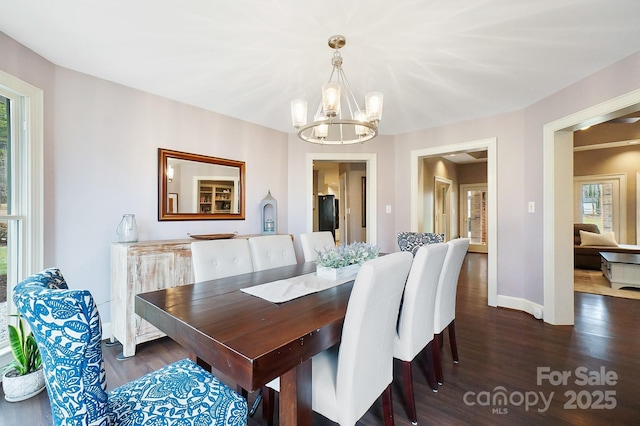 dining room featuring an inviting chandelier and dark wood-type flooring