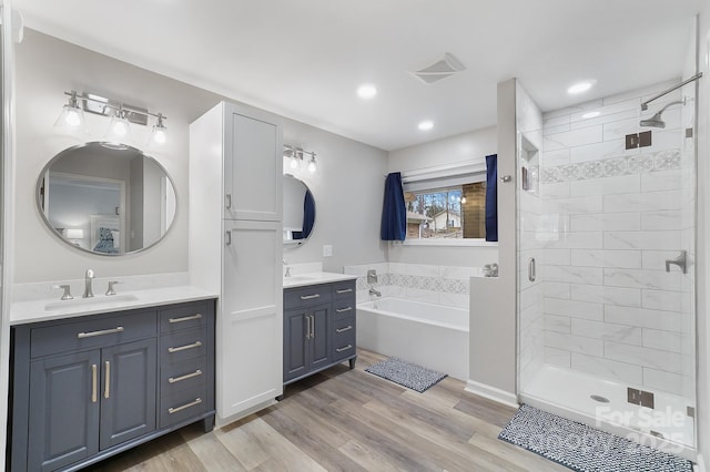 bathroom with vanity, wood-type flooring, and shower with separate bathtub