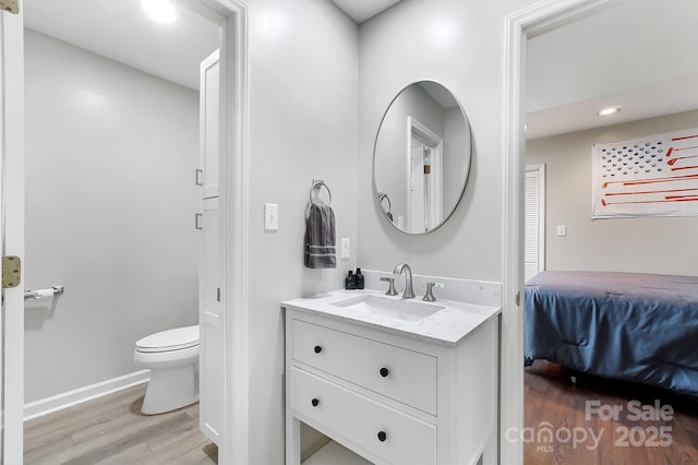 bathroom featuring vanity, hardwood / wood-style flooring, and toilet