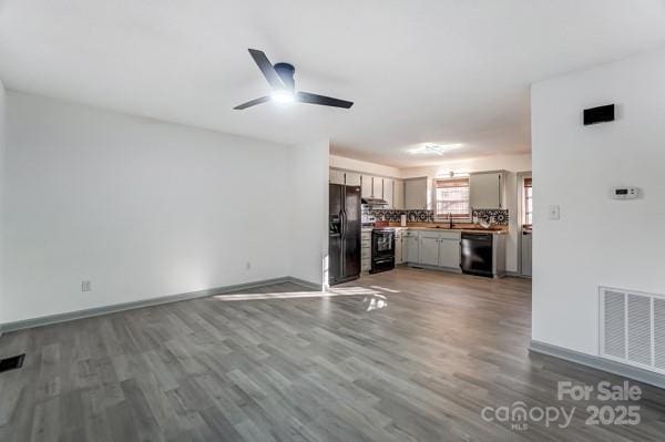 unfurnished living room with dark hardwood / wood-style floors and ceiling fan