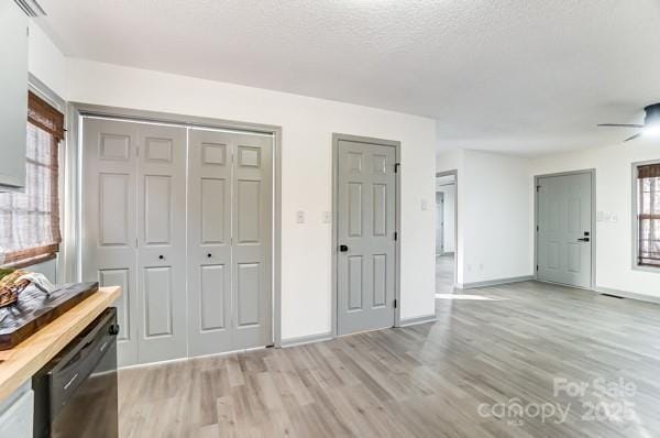 interior space with a textured ceiling and light hardwood / wood-style flooring