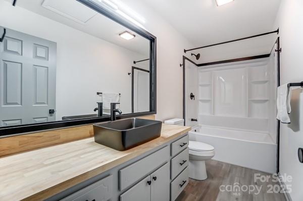 full bathroom featuring shower / tub combination, vanity, toilet, and wood-type flooring