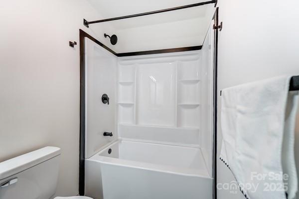 bathroom with shower / bathing tub combination and toilet