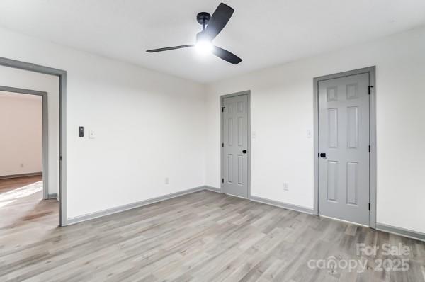 unfurnished bedroom with ceiling fan and light wood-type flooring