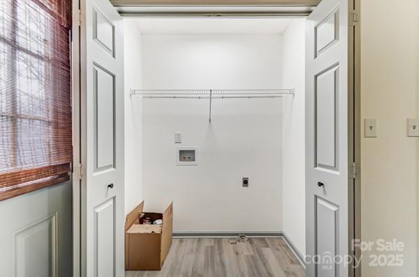 laundry room with hookup for a washing machine, electric dryer hookup, and light hardwood / wood-style floors