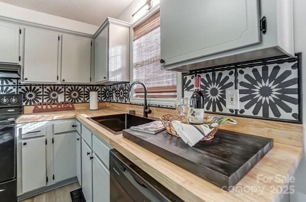 kitchen featuring electric stove, butcher block countertops, gray cabinetry, and sink