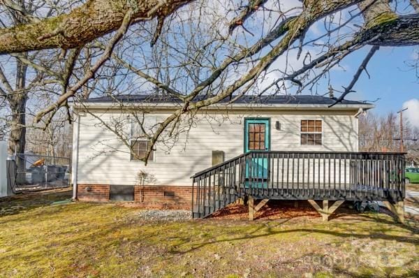 rear view of house with a yard and a deck