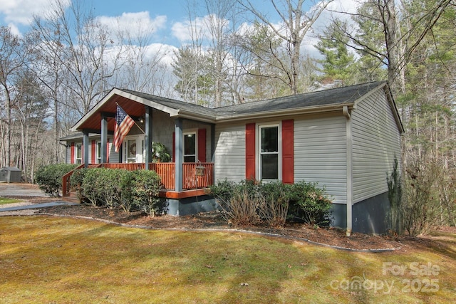 ranch-style home featuring covered porch and a front lawn