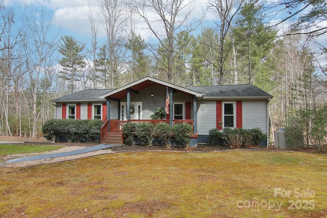 ranch-style home featuring a shed, a front lawn, and covered porch