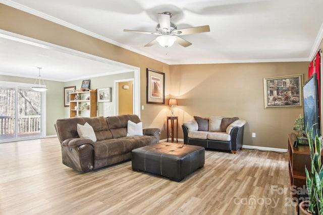 living room featuring ceiling fan, ornamental molding, and light hardwood / wood-style flooring