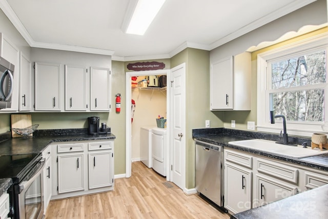 kitchen with sink, crown molding, washer and clothes dryer, stainless steel appliances, and white cabinets