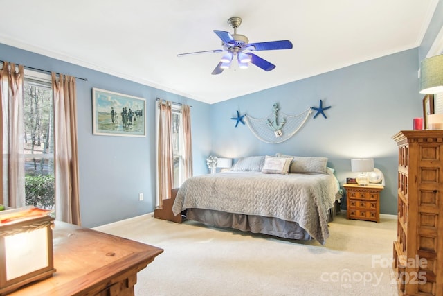 bedroom with crown molding, light colored carpet, and ceiling fan