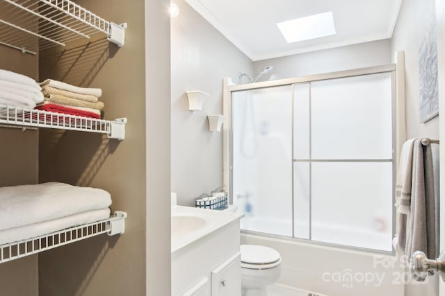 full bathroom with toilet, crown molding, bath / shower combo with glass door, a skylight, and vanity