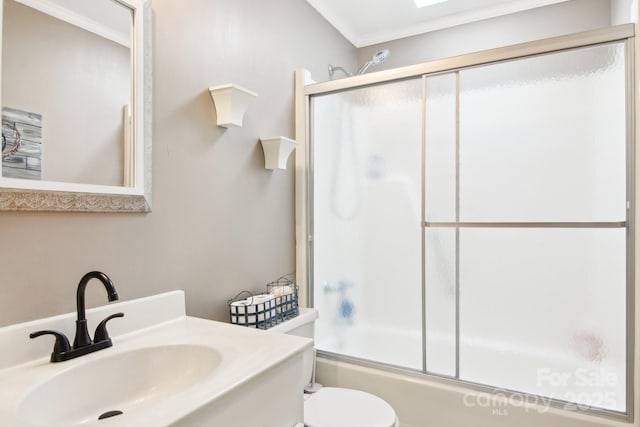 full bathroom with toilet, ornamental molding, bath / shower combo with glass door, and sink