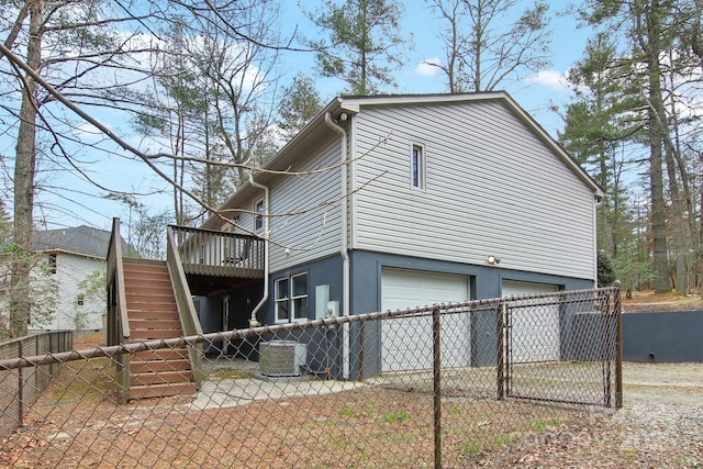 view of home's exterior with a wooden deck and a garage