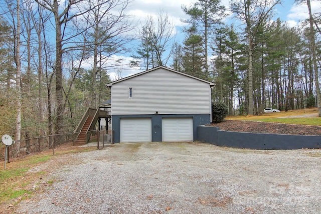 view of side of home featuring a wooden deck and a garage