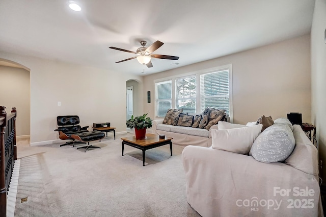 carpeted living room with ceiling fan