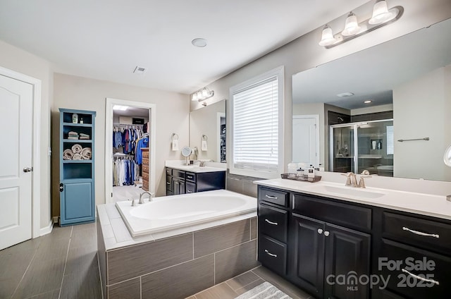 bathroom with vanity and shower with separate bathtub