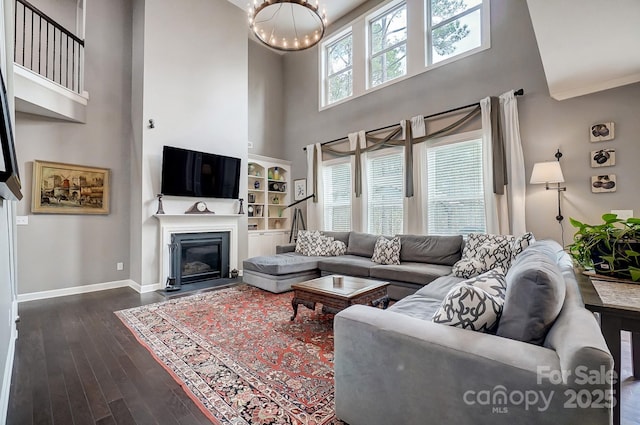 living room with dark hardwood / wood-style floors, a chandelier, and a high ceiling