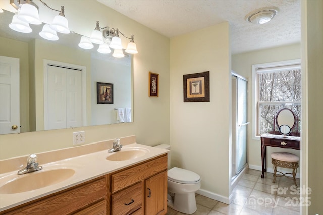 bathroom featuring vanity, tile patterned flooring, a shower with shower door, and a textured ceiling