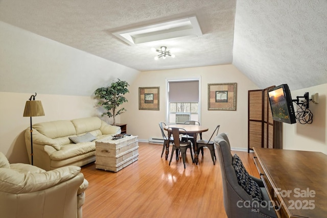 living room featuring a baseboard radiator, lofted ceiling, a textured ceiling, and light hardwood / wood-style floors