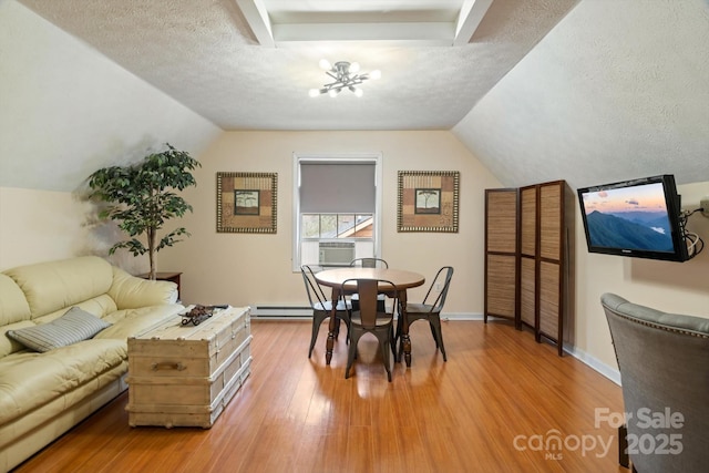 dining area featuring hardwood / wood-style flooring, lofted ceiling, and a textured ceiling