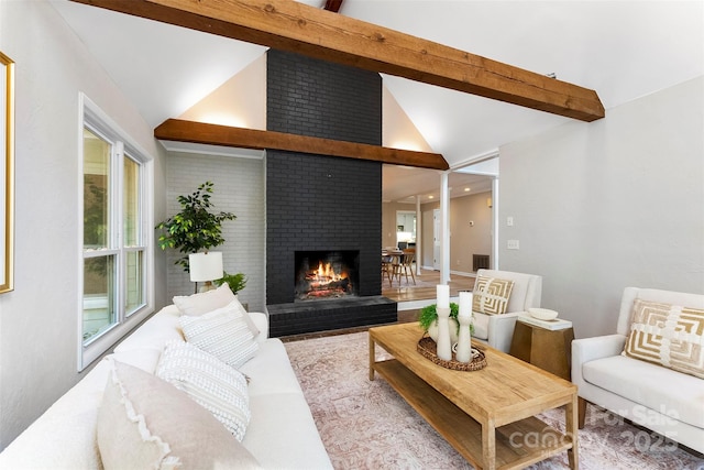 living room with a brick fireplace and lofted ceiling with beams