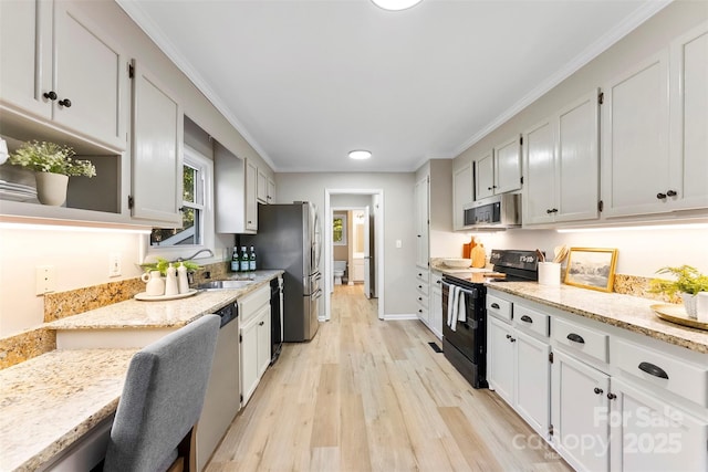 kitchen featuring sink, white cabinetry, crown molding, light stone counters, and appliances with stainless steel finishes