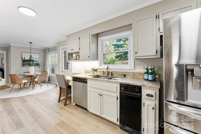 kitchen featuring stainless steel appliances, white cabinetry, hanging light fixtures, and sink