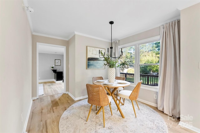 dining room with ornamental molding and light hardwood / wood-style flooring