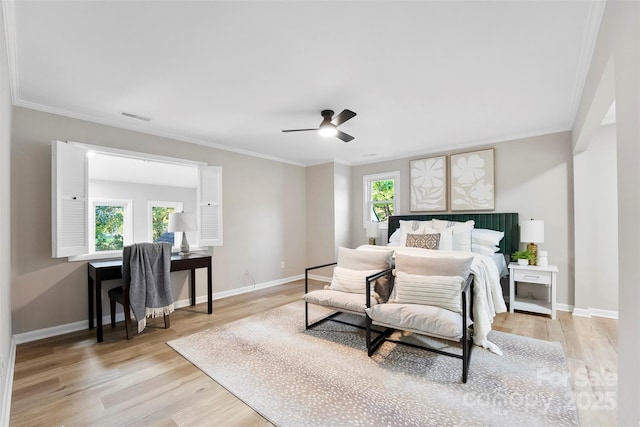 bedroom with multiple windows, ornamental molding, and light hardwood / wood-style flooring