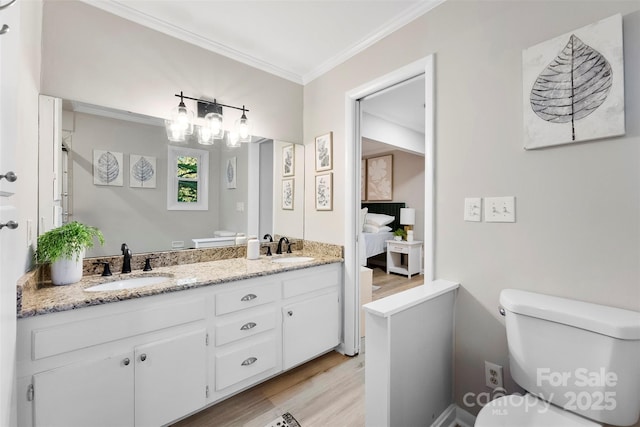 bathroom with crown molding, vanity, toilet, and hardwood / wood-style flooring