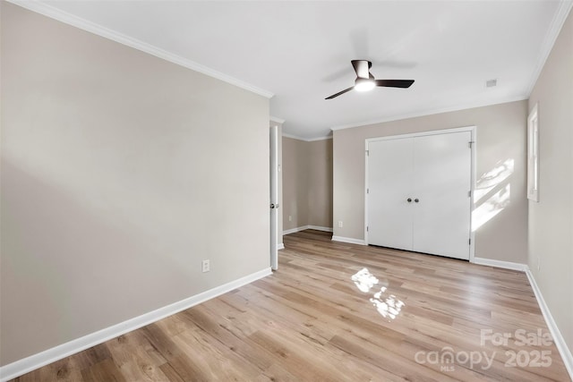 unfurnished bedroom with crown molding, a closet, ceiling fan, and light wood-type flooring