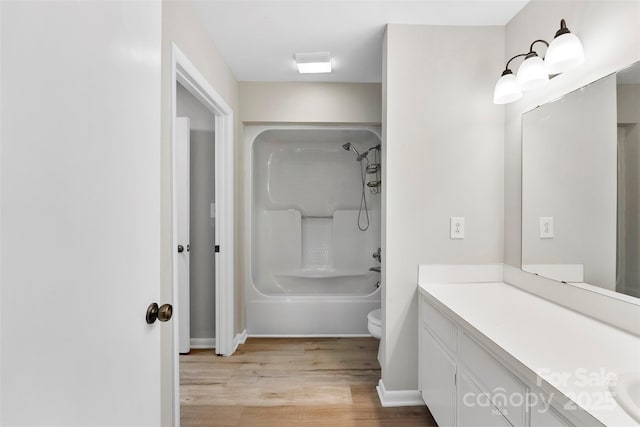 full bathroom with vanity, hardwood / wood-style flooring,  shower combination, and toilet