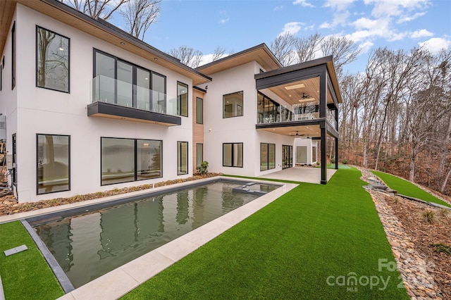 back of property with a patio area, a balcony, ceiling fan, and a lawn