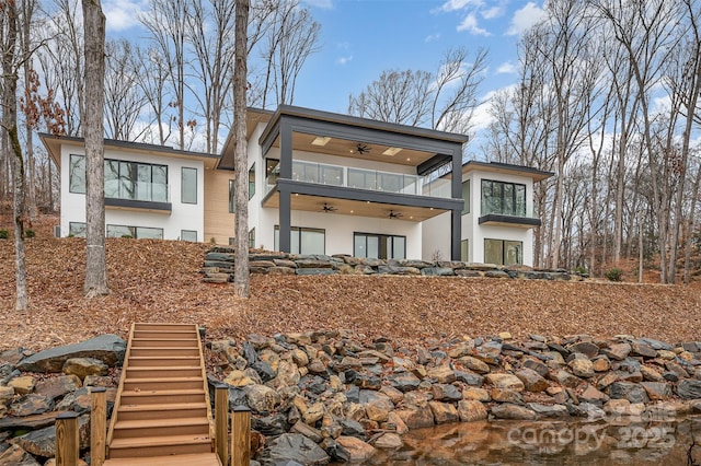 back of property featuring a balcony and ceiling fan