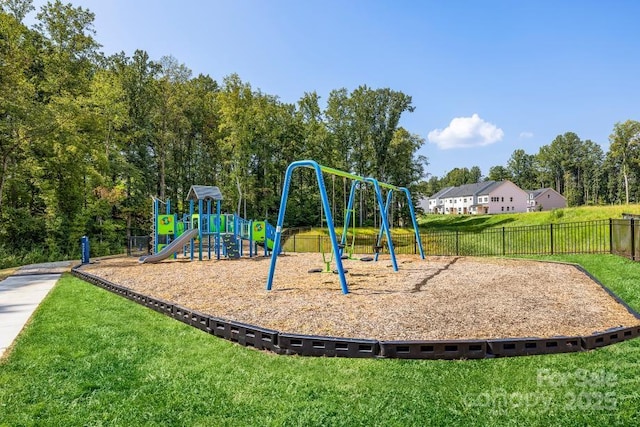 community playground featuring a lawn and fence