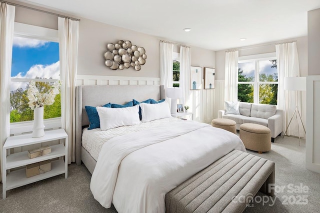 carpeted bedroom featuring a wainscoted wall