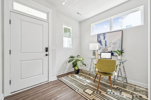 foyer featuring visible vents, wood finished floors, and baseboards