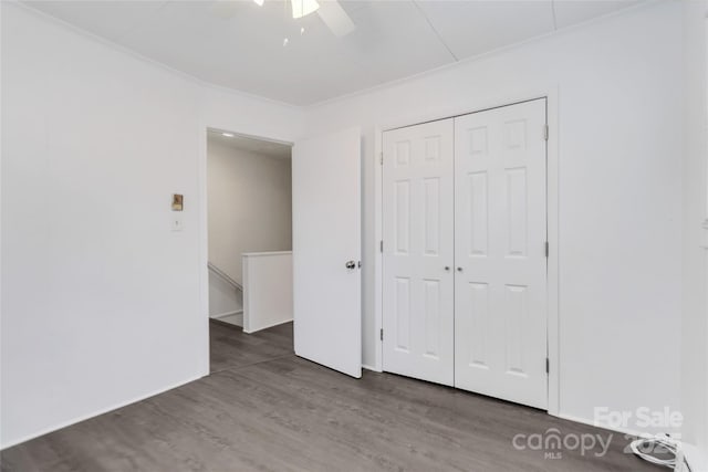 unfurnished bedroom featuring a closet, dark hardwood / wood-style floors, and ceiling fan