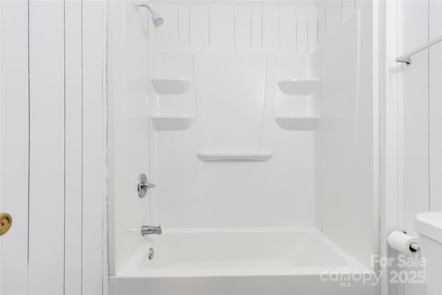 bathroom with washtub / shower combination and toilet