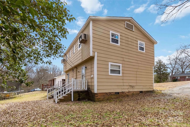 view of property exterior with a wall mounted AC and a trampoline