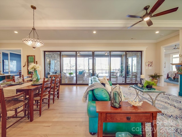 living room with crown molding, ceiling fan, and light hardwood / wood-style floors