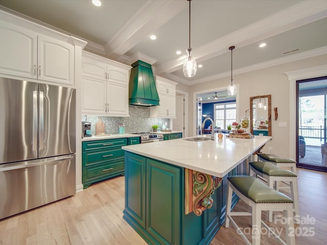 kitchen with premium range hood, stainless steel appliances, a center island with sink, and white cabinets