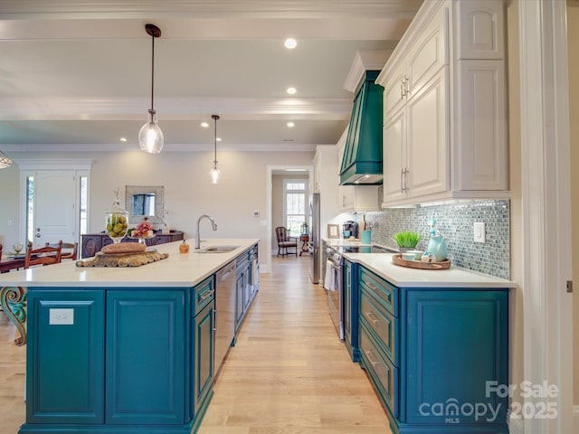 kitchen with sink, custom exhaust hood, white cabinets, and appliances with stainless steel finishes